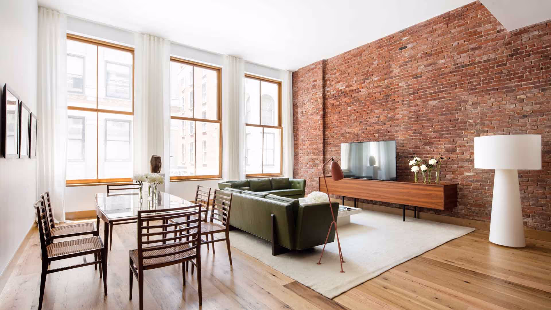 A brick-walled loft living room with Zola windows