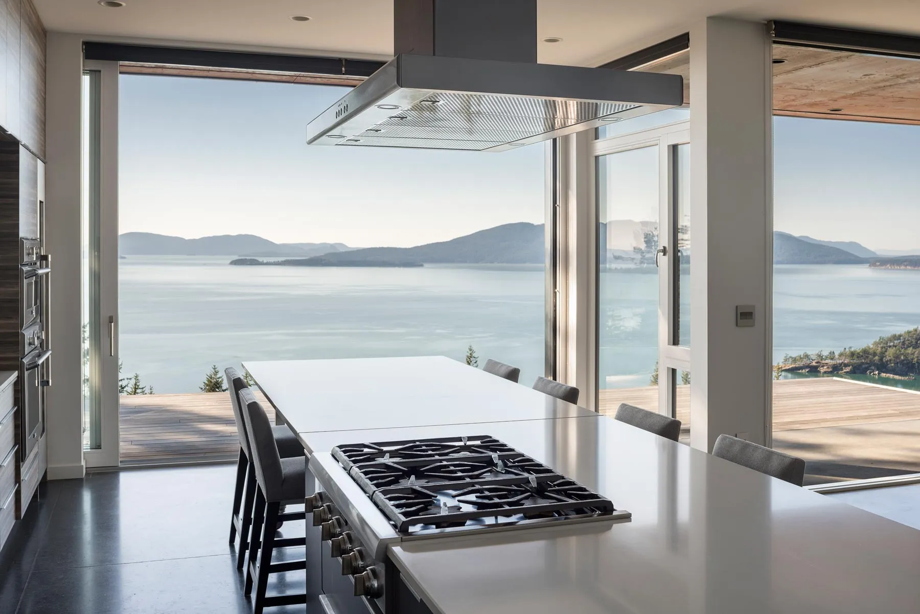 A kitchen island overlooking the water through Zola windows
