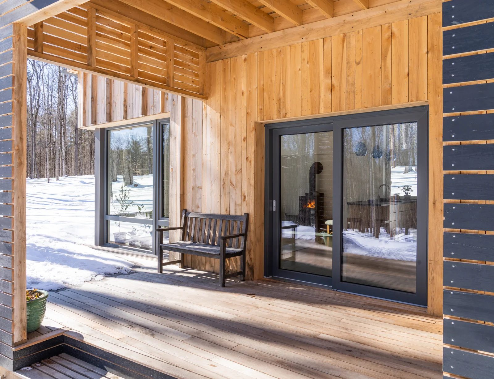 Sugar Bush House porch in winter, a Zola lift slide onto snow with the stove lit inside