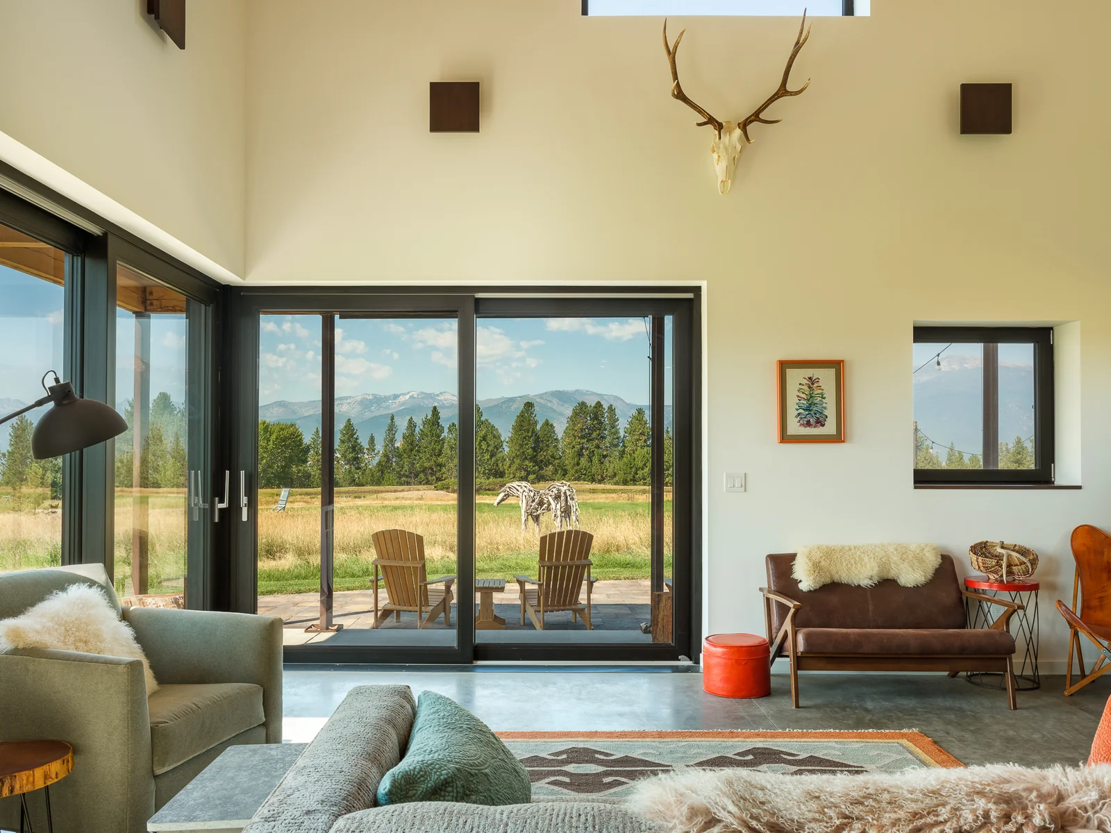 Sunset Bench living room — a Zola lift slide opening onto the meadow and mountains beyond