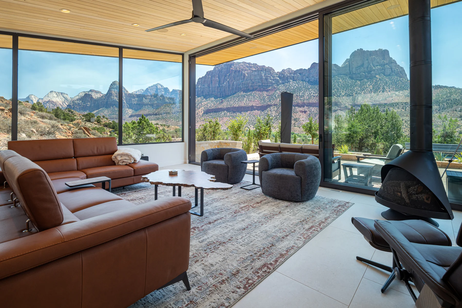 The Show living room, aluminum sliding walls framing the red cliffs above Springdale